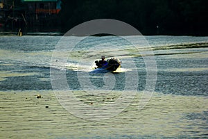 Silhouettes of boats fishing in running water.