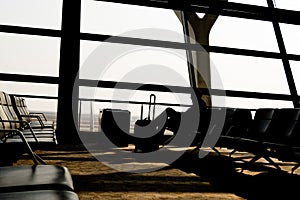 Silhouettes of business man at airport; waiting at the plane boarding gates.