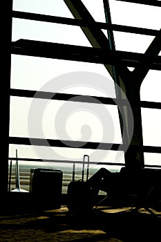 Silhouettes of business man at airport; waiting at the plane boarding gates.
