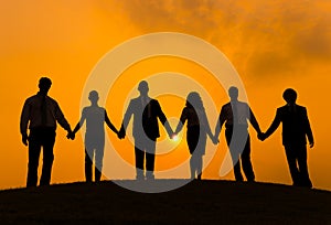 Silhouettes of Business People Holding Hands Outdoors