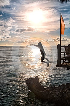 Silhouettes of child jumping in sea