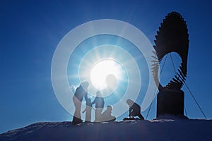 Silhouettes of children playing and riding on a snow slide, copy space