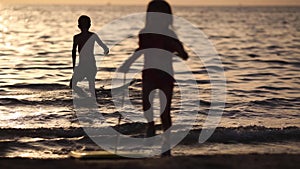 silhouettes of children during the summer holidays. relaxing at sea at the golden hour