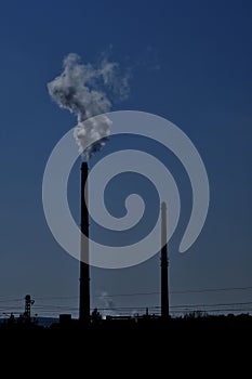 Silhouettes of chimneys with fog