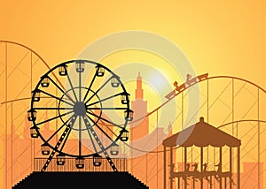 Silhouettes of a city and amusement park .