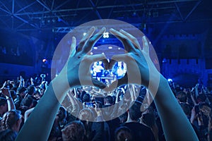 The silhouettes of concert crowd in front of bright stage lights