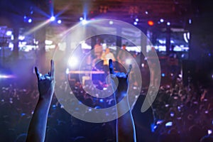 The silhouettes of concert crowd in front of bright stage lights