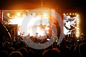 Silhouettes of concert crowd in front of bright stage lights