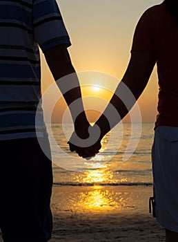 Silhouettes couples holding hands