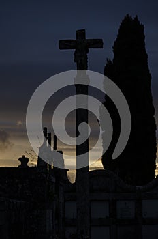 Silhouettes of crosses in a catholic cemetery at sunset