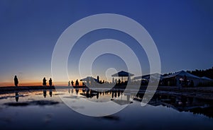 Silhouettes of crowd at seaside bar during sunset