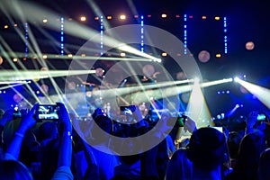 Silhouettes of crowds of spectators at a concert with smartphones in their hands