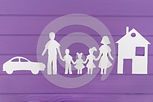 The silhouettes cut out of paper of man and woman with two girls and boy house and car near