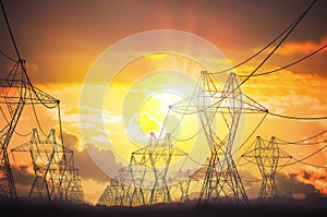 Silhouettes of electricity transmission pole in sunset