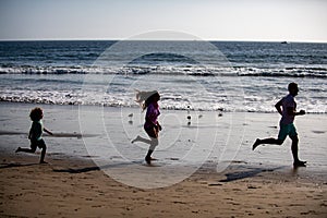 Silhouettes of family jogging along sea beach at sunrise. Outdoor workout, silhouettes of runners, sport and healthy