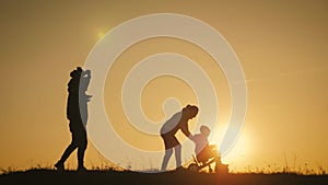 Silhouettes family is together at sunset. Young boy learning to ride bicycle, father teach his son to ride a bike in the