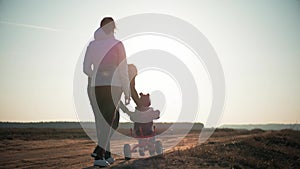 Silhouettes family is together at sunset. Young boy learning to ride bicycle, father teach his son to ride a bike in the