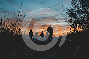 Silhouettes of a family on a trip, bonding under sunset