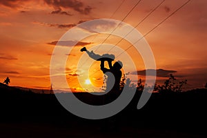 Silhouettes of father and son sunset background