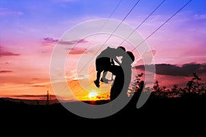 Silhouettes of father and son sunset background