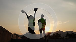 Silhouettes of female and male engineers. At the construction site where the work was inspected and completed as planned