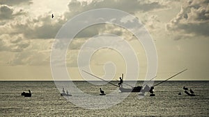 Silhouettes of fisherman on small fishing boat, with neotropic c photo