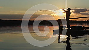 Silhouettes of fishermen at sunset of the sun.