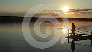 Silhouettes of fishermen at sunset of the sun.