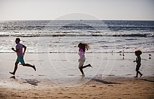 Silhouettes of fitness family running near sea. Family jogging for sport for fitness outdoors with child.