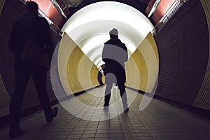 Silhouettes in front of a circular tunnel for pedestrians and cyclists