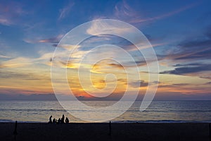 Silhouettes of group of people during the sunset in Seaside beach. Beautiful sunset over the sea with silhouettes happy group of