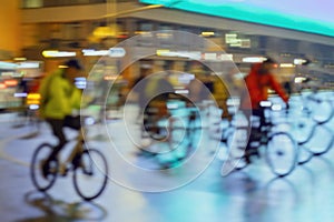 Silhouettes of group riding cyclists on the city roadway, night, illumination, abstract, motion blur. Concept of sport