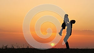 Silhouettes of happy child rushes into hands of father.