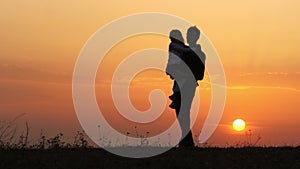 Silhouettes of happy child rushes into hands of father.