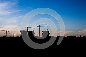 Silhouettes high-rise buildings under construction on background of the blue sky