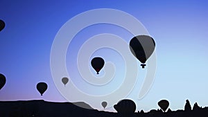 Silhouettes of hot air balloons on sunset sky background.