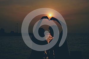 Silhouettes of hugging couple against the sea at sunset.