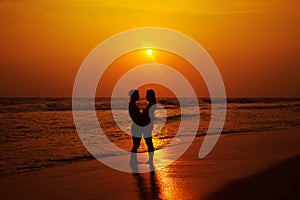 Silhouettes of a loving couple on the ocean shore.