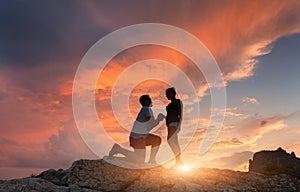 Silhouettes of a man making marriage proposal to his girlfriend