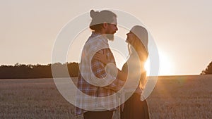 Silhouettes married couple girlfriend and boyfriend bearded man husband and woman wife lovers holding hands in wheat