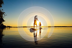 Silhouettes men, friends who are paddling on a SUP boards