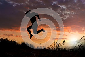 Silhouettes of men jumping with joy and freedom In the meadow during the evening time. man jump high and step on the sun in the si