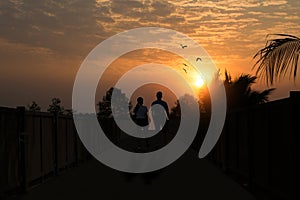 silhouettes of men and women exercising walking on a bridge in the park