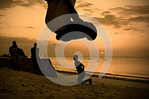 Silhouettes of men working out on the beach