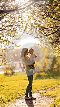 Silhouettes of mom and baby in the shade of trees