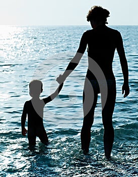 Silhouettes of Mother with a baby on beach