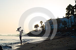 Silhouettes of mother and baby in sunset