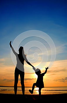 Silhouettes mother and child on sundown