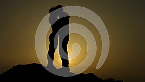 Silhouettes of newlyweds couple kissing passionately, romantic love story