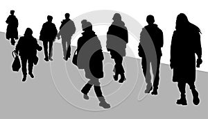 Silhouettes of people. A group of people walk towards each other. The people on the street are walking along the road.